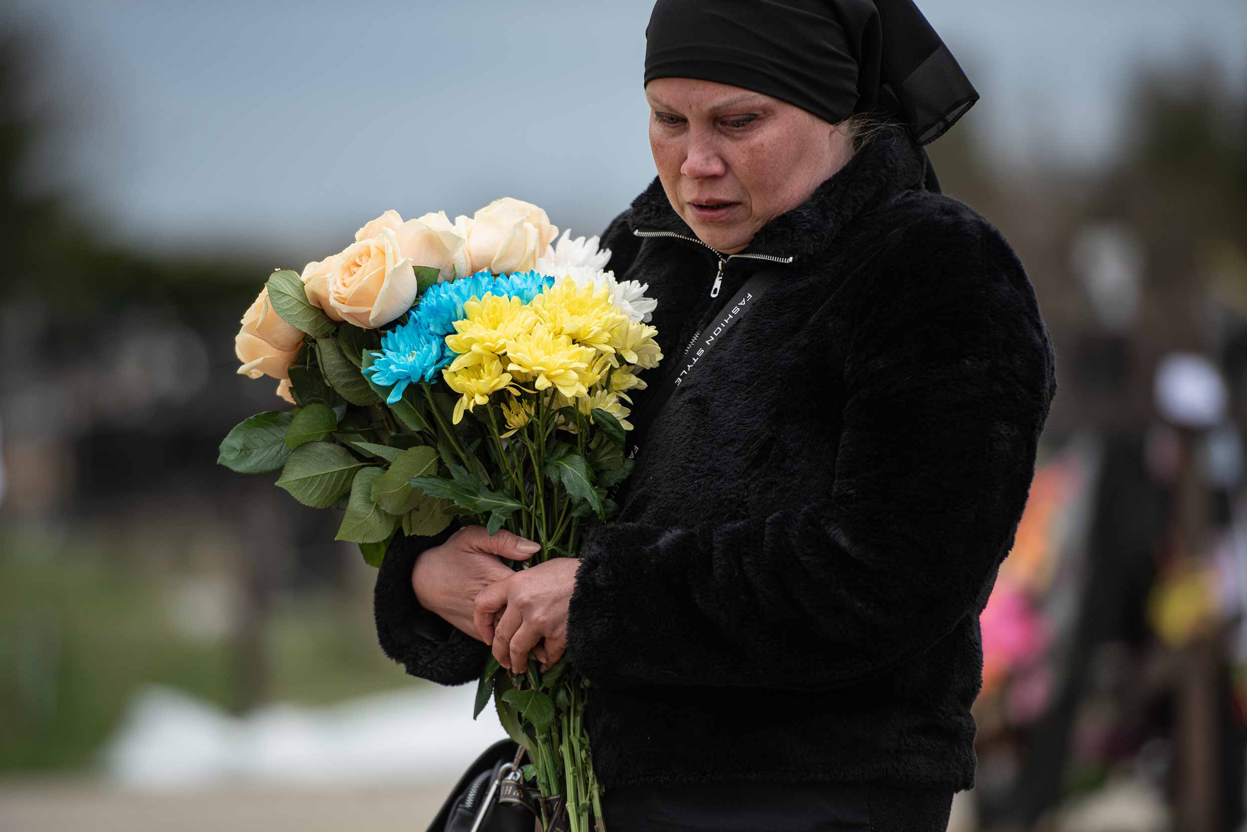 Hanna Hudyna, 43, stands by the grave of her mother Halyna Ponomareva on April 20, 2022 in Hostomel. Halyna Ponomareva was captured by Chechen fighters in Hostomel and was held in a basement as a prisoner. She died there after being held captive for 17 days. © Alexey Furman/Getty Images