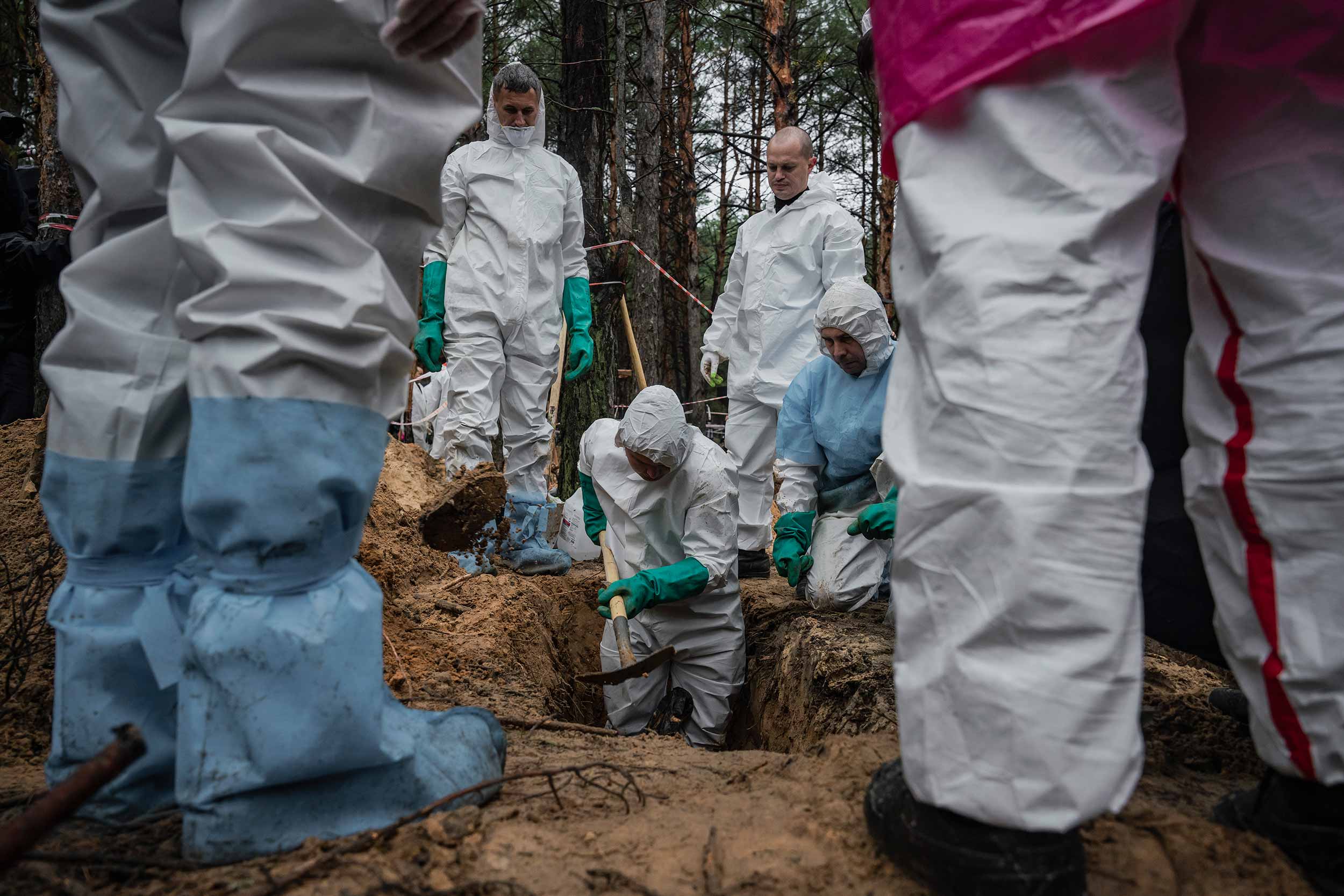 Protected by head-to-toe suits and rubber gloves, workers recover the remains of the victims. They carefully collect and classify all possible objects, which could help to identify those buried in unmarked graves. © Danil Pavlov
